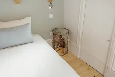 a bedroom with a bed and a basket on the floor at Downtown Clerigos Duplex With River View by Vacationy in Porto