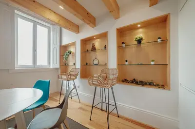 a room with a table and chairs and shelves at Downtown Clerigos Duplex With River View by Vacationy in Porto