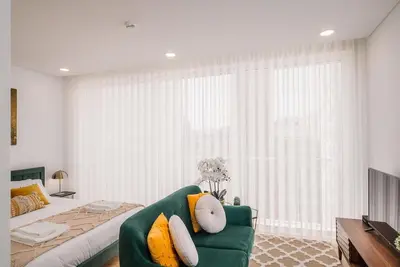 a bedroom with a green couch and a large window at Chimney Luxury House with AC in Porto