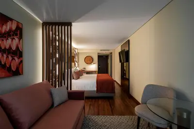 a living room with a couch and a bed at TURIM Oporto Hotel in Porto