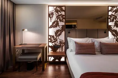 a hotel room with a bed and a desk at TURIM Oporto Hotel in Porto