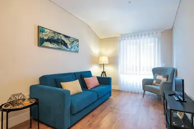 a living room with a blue couch and a chair at Virtudes Flat in Porto