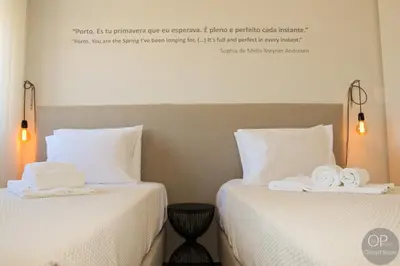 two beds in a hotel room with towels on them at 115 OPorto Guest House in Porto