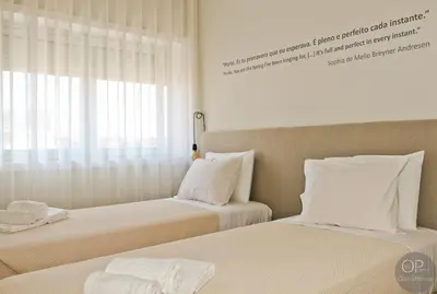 a bedroom with two beds with white sheets and a window at 115 OPorto Guest House in Porto