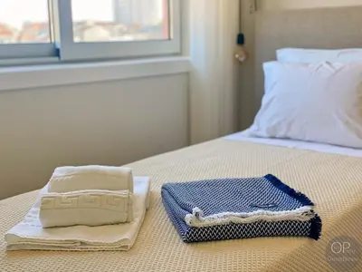 a bed with two towels and a tray on it at 115 OPorto Guest House in Porto