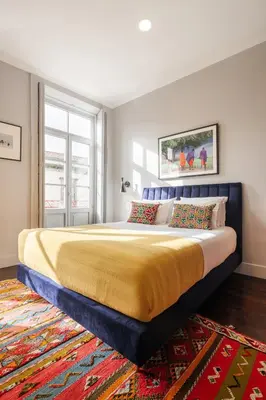 a bedroom with a large bed with a yellow blanket at Utopian - Design Suites Porto - Free Minibar in Porto