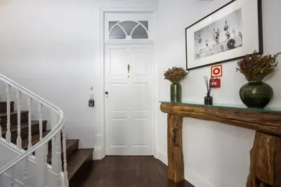 a hallway with a console table with flowers on it at Utopian - Design Suites Porto - Free Minibar in Porto