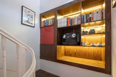 a book shelf with a tv on a wall at Utopian - Design Suites Porto - Free Minibar in Porto