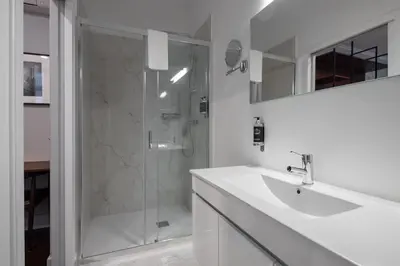 a white bathroom with a sink and a shower at Utopian - Design Suites Porto - Free Minibar in Porto