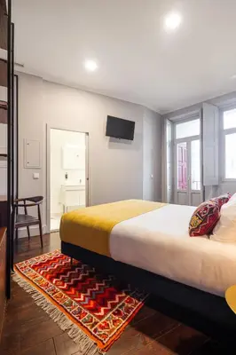 a bedroom with a large bed and a tv on the wall at Utopian - Design Suites Porto - Free Minibar in Porto