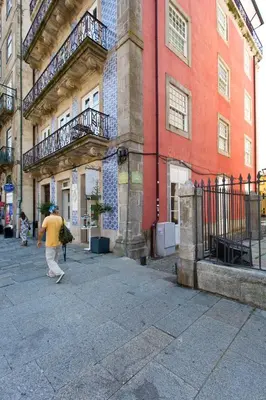 a man walking down a street in front of a building at BOUTIQUE Rentals- DOURO Ribeira historical center with parking in Porto