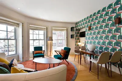 a living room with chairs and tables and a wall at BOUTIQUE Rentals-Isabella Ribeira Apt great views in Porto