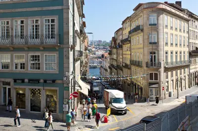 a group of people walking on a busy city street at BOUTIQUE Rentals-Isabella Ribeira Apt great views in Porto