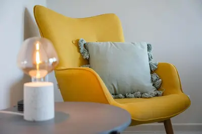 a yellow chair with a pillow and a lamp on a table at GuestReady - Amazing stay near Cedofeita Church in Porto