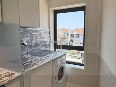 a kitchen with a washing machine and a window at Atayde da Câmara - Porto in Porto
