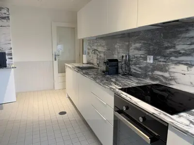 a kitchen with white cabinets and marble counter tops at Atayde da Câmara - Porto in Porto