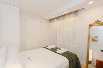 a white bedroom with a bed and a mirror at Liiiving in Porto - Downtown Secret Terrace in Porto
