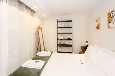 a bedroom with a white bed and a shelf at Liiiving in Porto - Downtown Secret Terrace in Porto