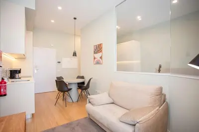a white room with a bed and a mirror at Liiiving in Porto - Sweet Sunlight Apartment in Porto