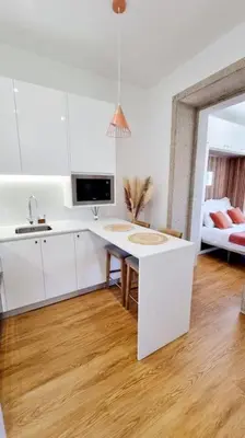 a white kitchen with a sink and a table at Glamour Dreaming Studio in Porto