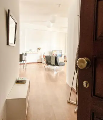 a living room with white walls and a wooden floor at Central Loft with free parking in Porto