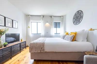 a bedroom with a large bed and a tv at S. Lázaro Studio in Porto