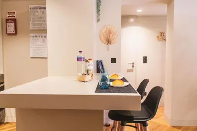 a kitchen with a island with two chairs and a counter top at São Lázaro's Garden - Apartment With Terrace in Porto
