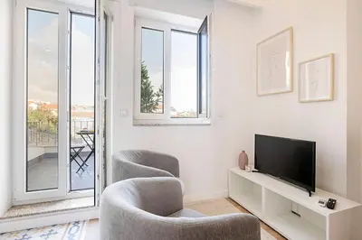 a living room with two chairs and a television at Urban House by LovelyStay in Porto