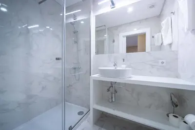 a white bathroom with a sink and a shower at Formosa Apartments by Amber Star Rent in Porto