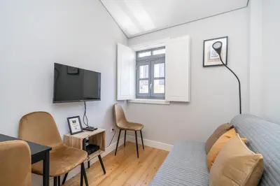 a living room with a couch and a tv at Formosa Apartments by Amber Star Rent in Porto
