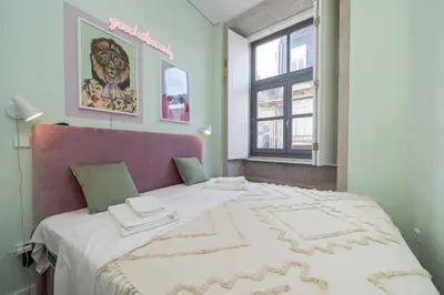a bedroom with a large bed with a purple headboard at Formosa Apartments by Amber Star Rent in Porto