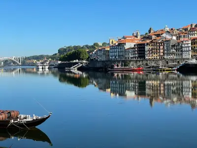 a boat in a river with buildings and a city at Casa Anibal artistic Centrally located comfortable affordable in Porto