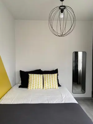 a bedroom with a bed with yellow pillows and a chandelier at Casa Anibal artistic Centrally located comfortable affordable in Porto