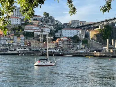 a sail boat in the water in front of a city at Casa Anibal artistic Centrally located comfortable affordable in Porto