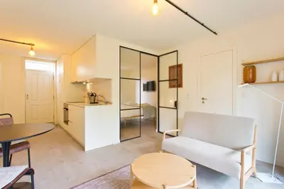 a bedroom with a large white bed with orange pillows at Zen Garden Studio B in Porto