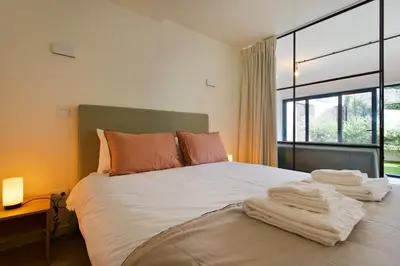 a living room with a blue couch and sliding glass doors at Zen Garden Studio A in Porto