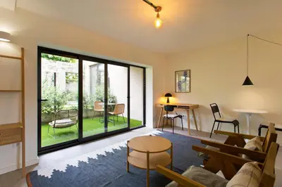 a living room with a couch and a table at Zen Garden Studio D in Porto