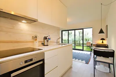 a white kitchen with a sink and a counter at Zen Garden Studio D in Porto