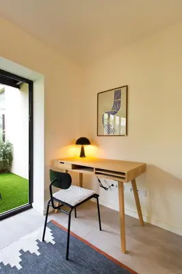 a desk with a chair in a room with a window at Zen Garden Studio D in Porto