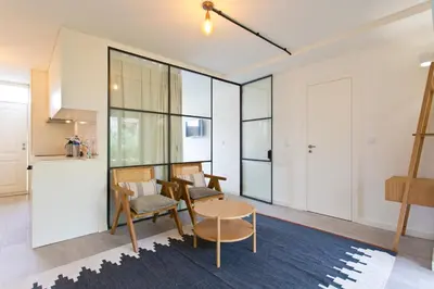 a living room with large windows and a table at Zen Garden Studio D in Porto