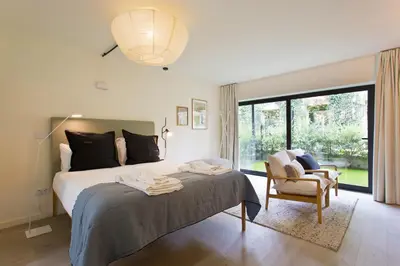 a bedroom with a bed and a chair and a window at Zen Garden Studio C in Porto