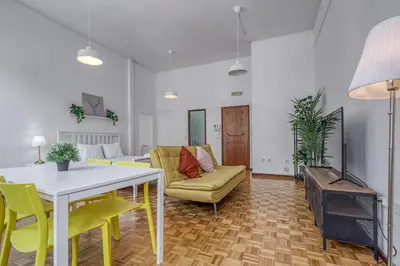a living room with a table and yellow chairs at Travel & Live Alegria 248 in Porto