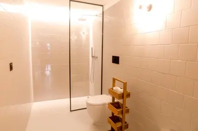 a bathroom with a toilet and a glass shower at Alegria Suítes By Porto City Hosts in Porto