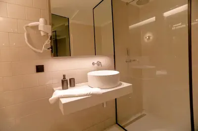a bathroom with a sink and a shower at Alegria Suítes By Porto City Hosts in Porto