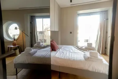 a bedroom with a bed and a large window at Alegria Suítes By Porto City Hosts in Porto