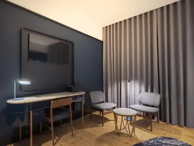 a living room with a chair and a window at Axis Porto Club Aliados in Porto
