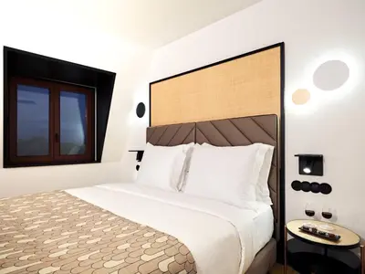 a bedroom with a large bed and a chair at Axis Porto Club Aliados in Porto