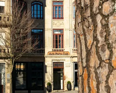 a bedroom with a king sized bed and a chair at Axis Porto Club Aliados in Porto