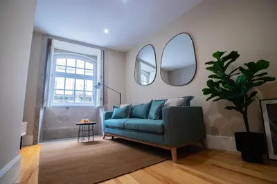 a living room with a blue couch and two mirrors at Almada 1.3 by LovelyStay in Porto