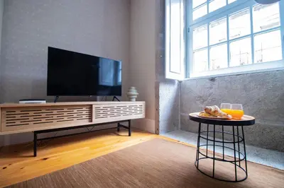a living room with a flat screen tv on a entertainment center at Almada 1.3 by LovelyStay in Porto